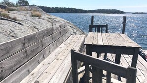 A wooden dock with benches overlooking a calm body of water. - Stockholm  Archipelago – Idyllic Island (Värmdö)
