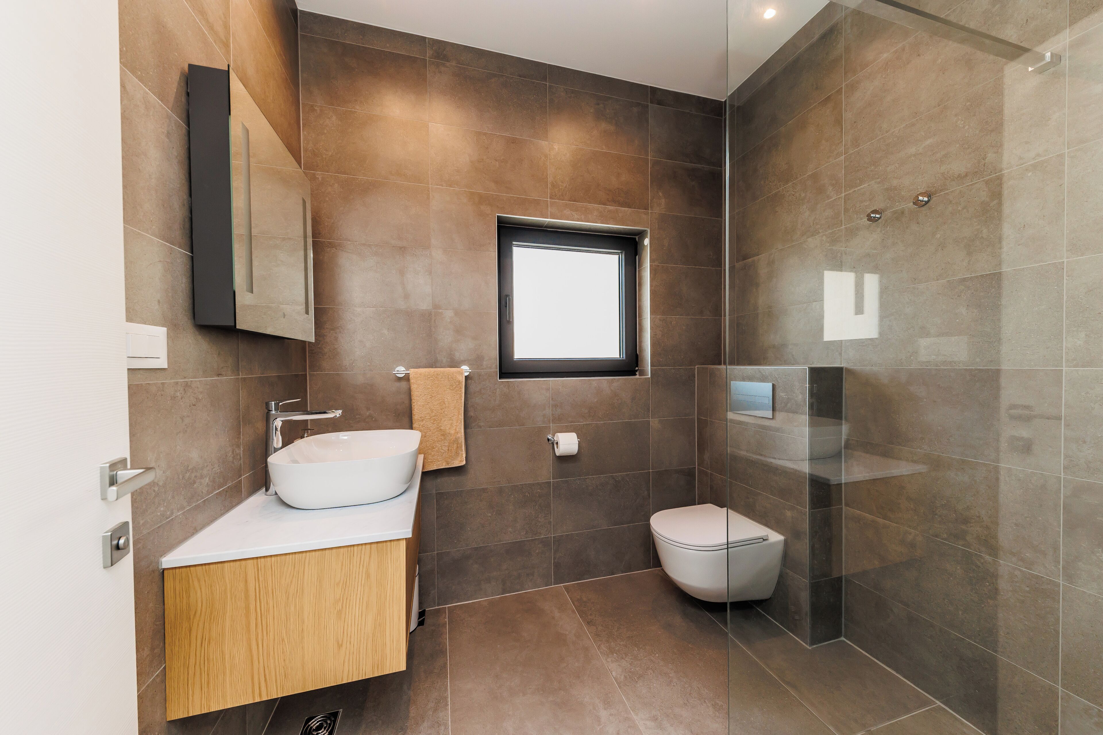 Une salle de bain moderne avec un grand lavabo, des toilettes et une douche à parois de verre.