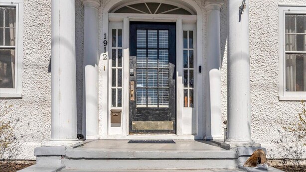 A white building with a black door, numbered 1912, and a small dog on the steps. - Lakeside Vintage Retreat | Classic RVA Charm (Henrico)