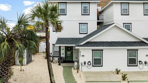 A two-story house with a green door and a small porch.