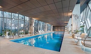 Relax by the rectangular pool surrounded by lounge chairs and tables.