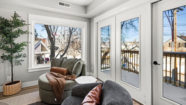 A modern living room with a large window, a potted plant, and a gray sofa with cushions. - Luxury Condo w/ Beach Access | Dragestil 715-2 (Duluth)