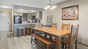 Una cocina amplia con una isla central, mesa de comedor de madera y bancos.