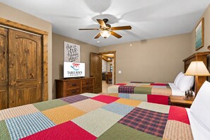 Ein Hotelzimmer mit zwei Betten, einem Deckenventilator, einem Schild mit der Aufschrift 'Das ist unser glücklicher Ort' und einem Schild für 'Table Rock Resorts'.