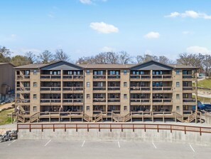 A multi-story building with balconies and a parking area in front. - Morning Coffee with Lake Views Starts Here (Branson)