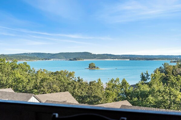 A view of a lake with a small island, surrounded by trees and hills in the background. - Studio Condo overlooking Table Rock Lake, 2 min to SDC, Ticket Deals, Resort Perks! (Branson)