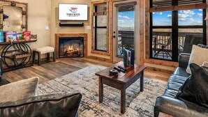 Ein Wohnzimmer mit Kamin, Ledersofas, einem Couchtisch und einem Fernseher, der das Logo von Table Rock Resorts zeigt.