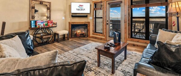 Ein Wohnzimmer mit Kamin, Ledersofas, einem Couchtisch und einem Fernseher, der das Logo von Table Rock Resorts zeigt.