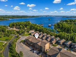 A residential area with a large building, parking, and a lake. - Lakeview Penthouse Near Silver Dollar City • Sleeps 13 • Boat Slip (Branson)