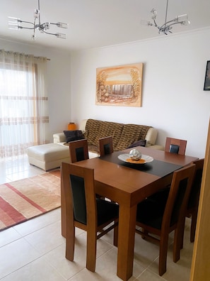 Un coin repas avec une table en bois, des chaises et un tableau accroché au mur.