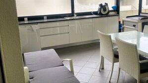 Keittiössä on ikkuna, pesuallas ja pöytä tuoleineen.