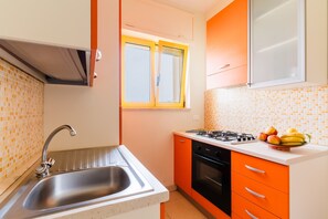 Eine Küche mit Spüle, Herd und einem Fenster mit Jalousien.