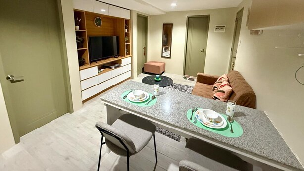 A compact living space with a dining area, a television, and a small seating area.