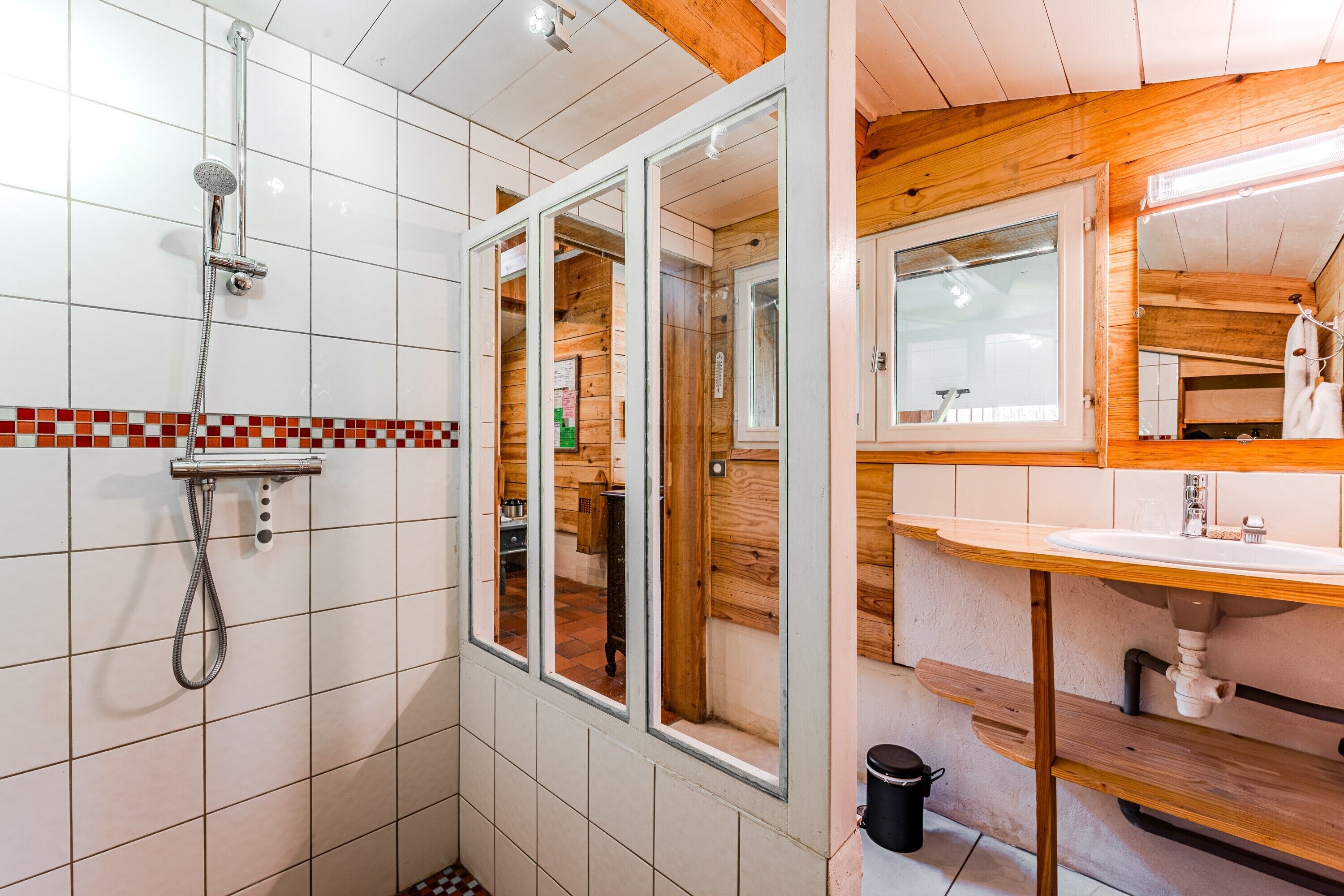Un baño con ducha, lavabo y espejo.
