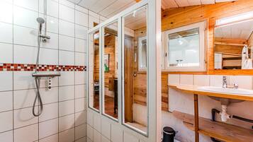 Un baño con ducha, lavabo y espejo.