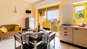 Une cuisine moderne avec un coin repas, un canapé et un téléviseur.