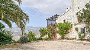 Un edificio con un balcone, vista sul paesaggio e una palma.