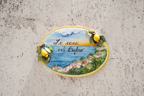 Uma placa decorativa com uma paisagem costeira e texto.