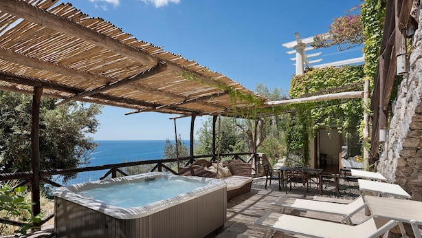 Un bain à remous, des chaises longues et une vue sur la mer.