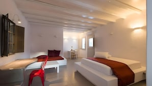 Ett modernt hotellrum med en säng, ett skrivbord, en stol och ett litet bord.