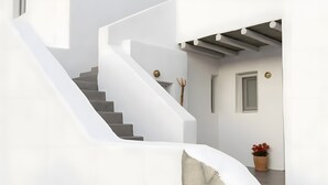 A modern staircase with a stone accent wall, a potted plant, and a door with a brass doorknob.