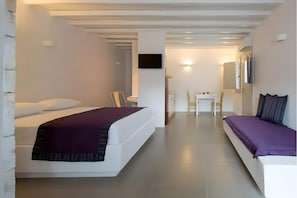 A modern hotel room with a bed, a desk, and a chair.