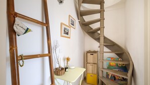 A spiral staircase, a desk with a basket, and a small cabinet with colorful boxes. - Mediterranean Escape Between the Sea and the Esterel Mountains (Théoule sur Mer)