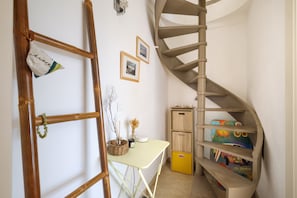 A spiral staircase, a desk with a basket, and a small cabinet with colorful boxes. - Mediterranean Escape Between the Sea and the Esterel Mountains (Théoule sur Mer)