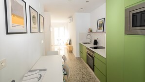 Una cucina moderna con mobili verdi, un piano di lavoro bianco e un forno in acciaio inossidabile.