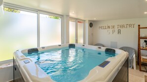 A spa with a hot tub, frosted windows, and a wall sign reading 'MELINDE TARTAY SPA'.