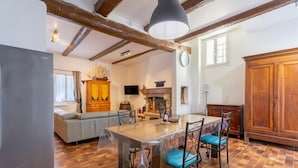 A kitchen with a wooden table, chairs, a sofa, and a cabinet.