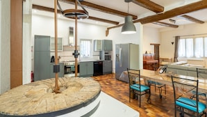 A spacious kitchen with modern appliances, a dining area with chairs, and a large wooden dining table.