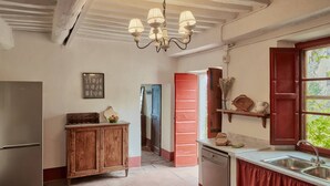 Una cocina con refrigerador, mueble de madera y ventana con vistas.