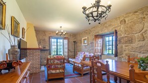 Ein rustikales Zimmer mit Steinwänden, Holzmöbeln und einem Kamin.