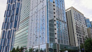 A modern high-rise building with a glass facade, surrounded by other tall buildings. - NEWCZ CENTUM HOTEL (Busan)