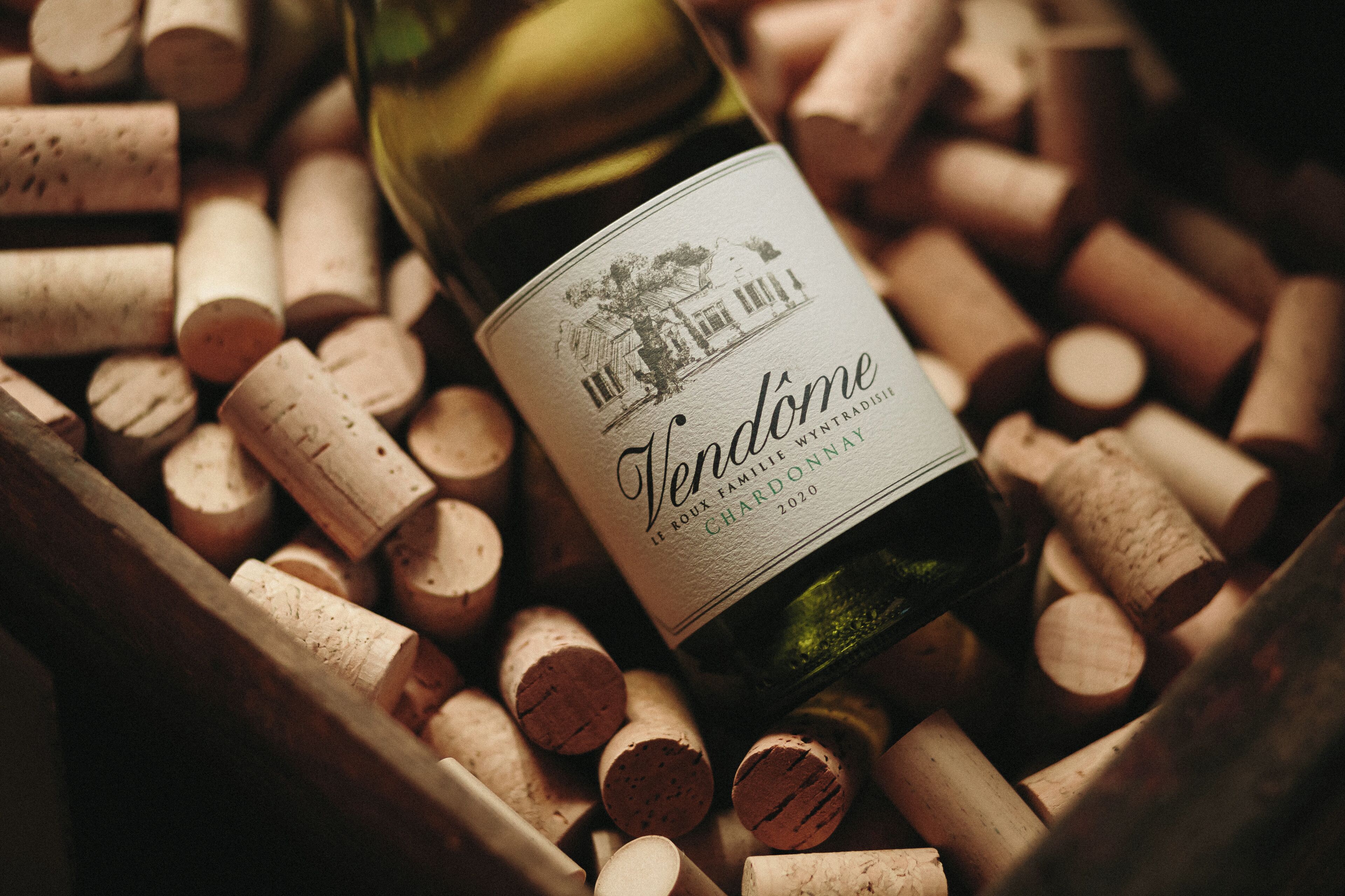 A bottle of wine with a label, surrounded by numerous wine corks.