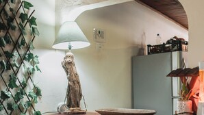 A kitchen area with a wooden counter, two bar stools, a hanging plant, and a lamp. - Dominical Long Term Rental (Bahía Ballena)