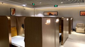 Ein Hotelzimmer mit Holzwand, einem Bett, einem Sessel und einem kleinen Tisch.