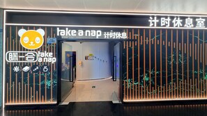 Entrada de hotel con un letrero que dice 'échate una siesta' e ícono de panda.