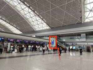 Una terminal aeroportuaria amplia con techo alto y diseño moderno.