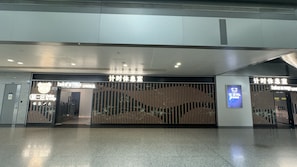 Entrada de hotel con diseño moderno, destacando una puerta de vidrio amplia y un letrero con el logo de un oso.