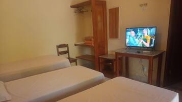 Una habitación con dos camas individuales, un escritorio de madera, un televisor y una silla.