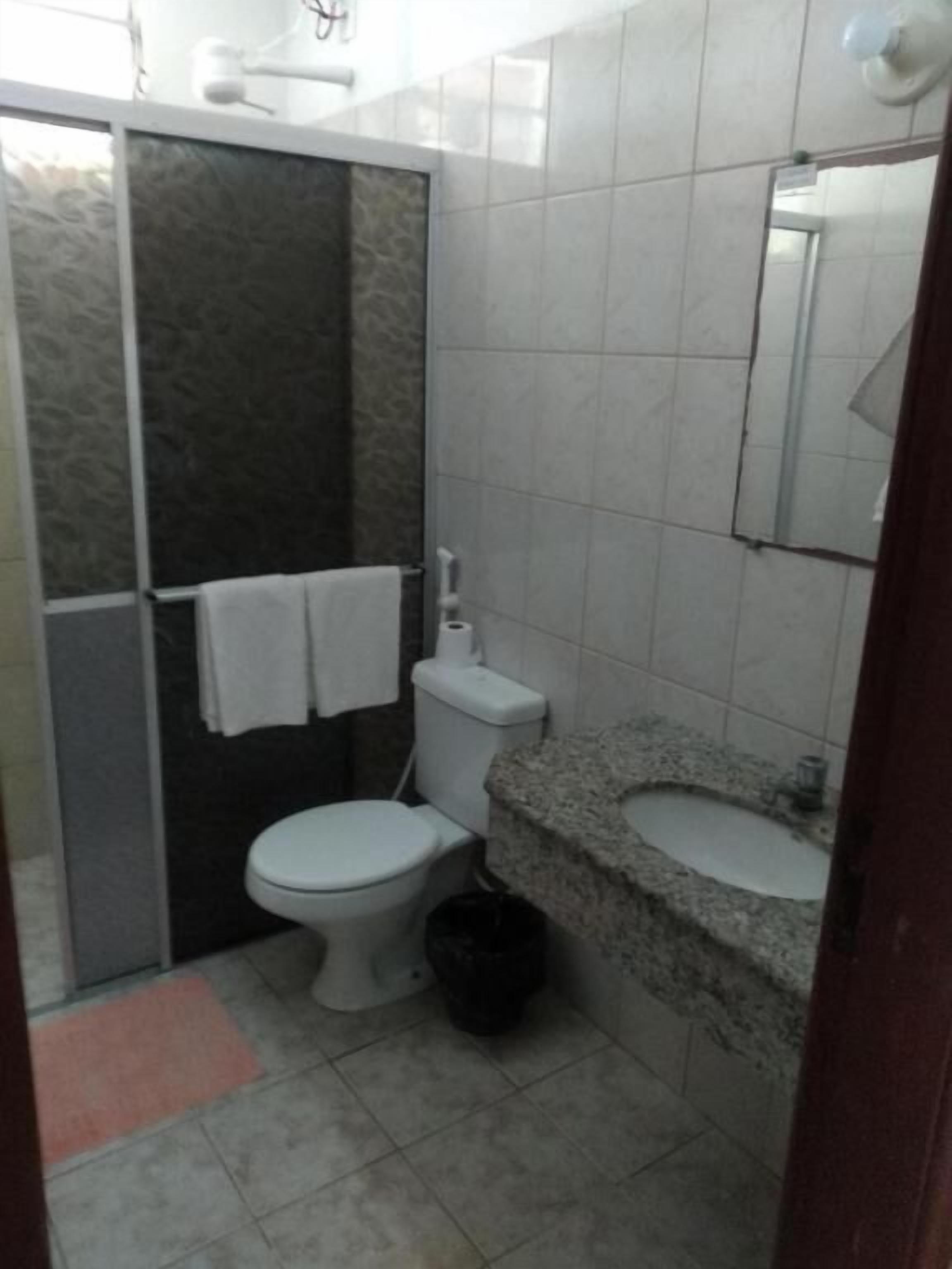 Une salle de bain équipée de toilettes, d’un lavabo et d’une douche.