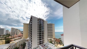 Un edificio alto con varios balcones y vistas al mar.