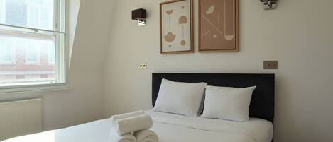 2 habitaciones, escritorio y tabla de planchar con plancha