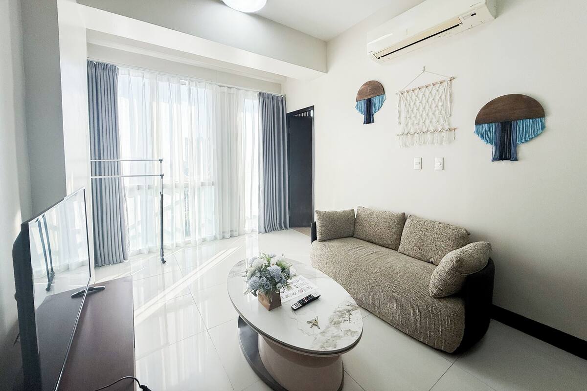 A modern living room with a sofa, a coffee table, and a TV.