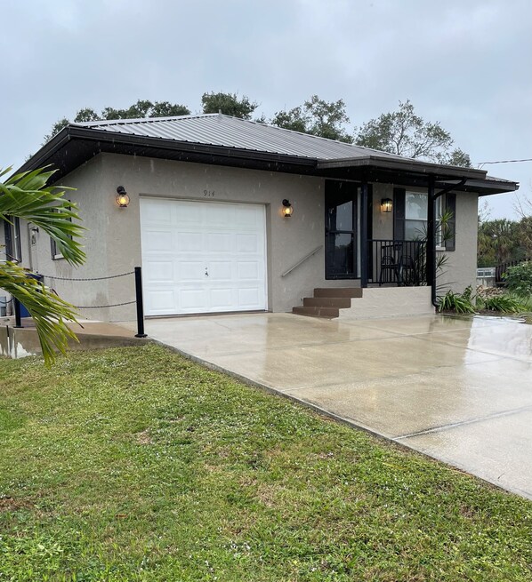 A two-story house with a garage, a covered porch, and a concrete driveway. - Pinecraft - the House at Phillippi Crossing - 3 bedroom, 3 bathroom (Sarasota)