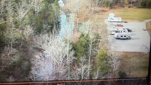 A surveillance camera feed of a campground with RVs and a white trailer. - Perfect RV campground in Ravenden Springs for a peaceful getaway (Ravenden Springs)