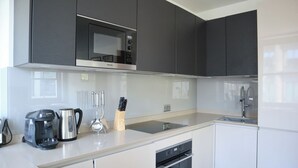 A modern kitchen with a Bosch microwave, a coffee maker, and a dishwasher.