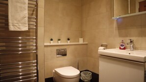 A modern bathroom with a toilet, sink, and towel rack.